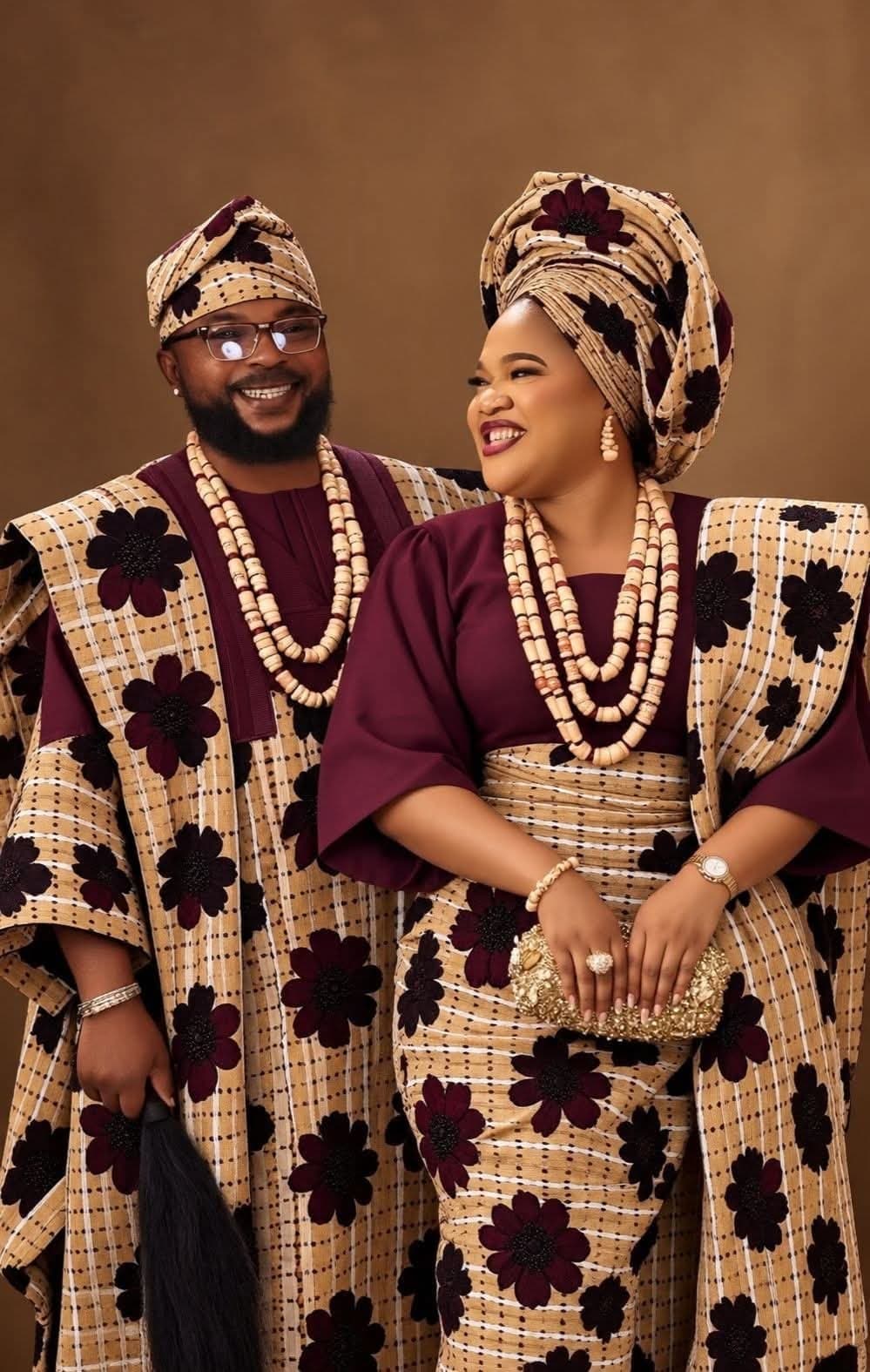 Couple in coordinated burgundy and beige ceremonial outfits