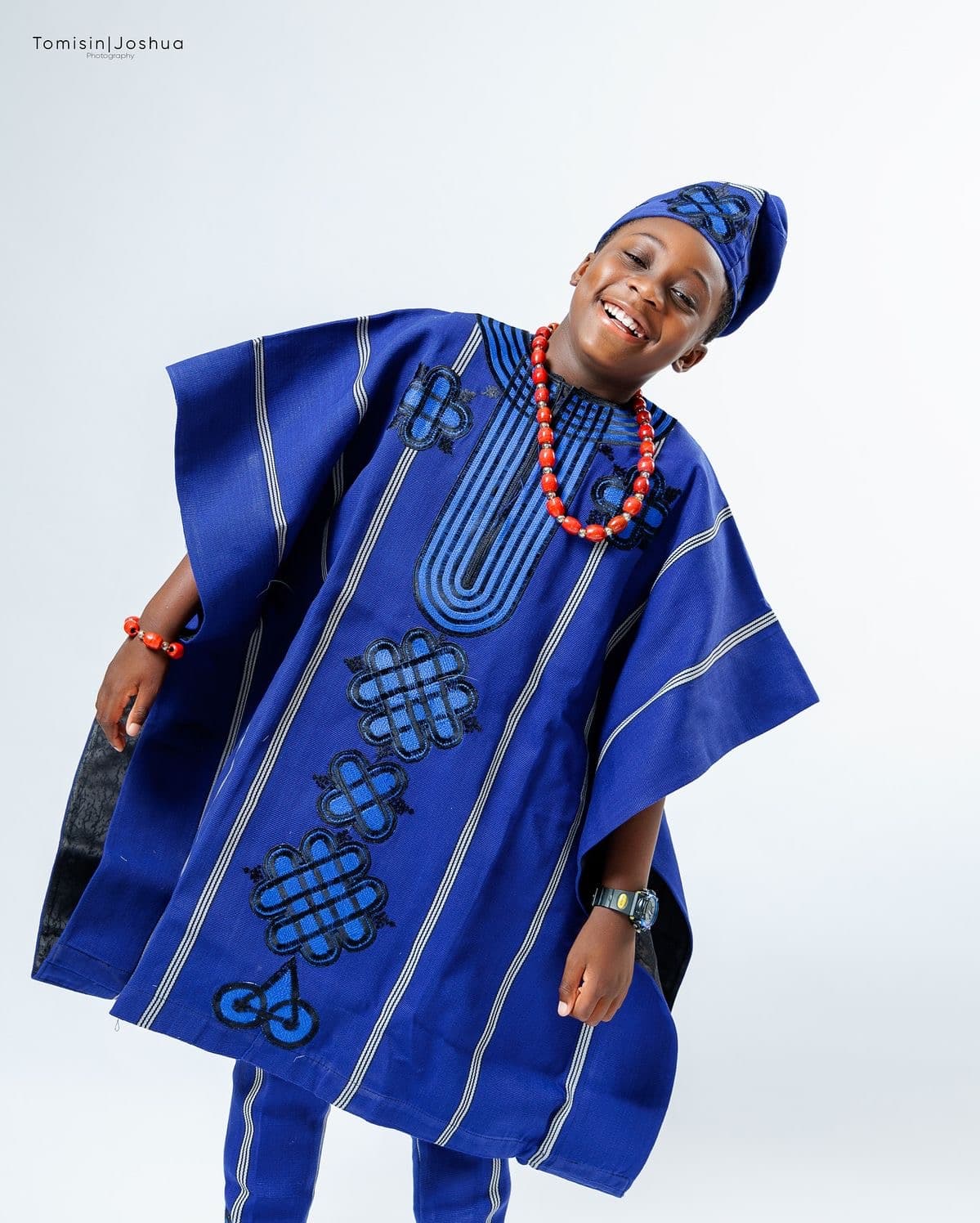 Woman in a royal blue traditional ensemble with coral beads