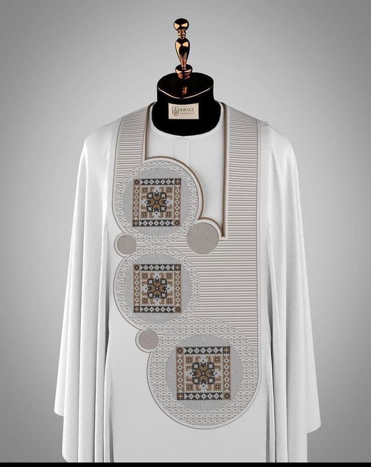 Ivory formal garment with intricate stitched decoration on mannequin