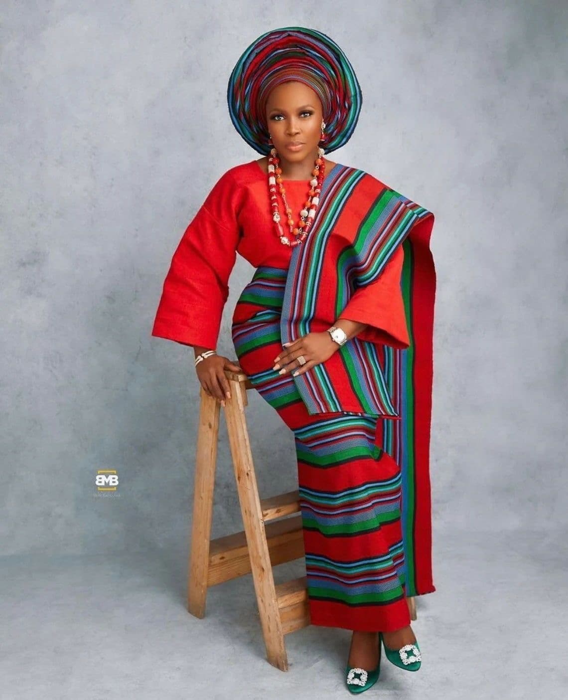 Woman dressed in red and multicolour traditional wrap
