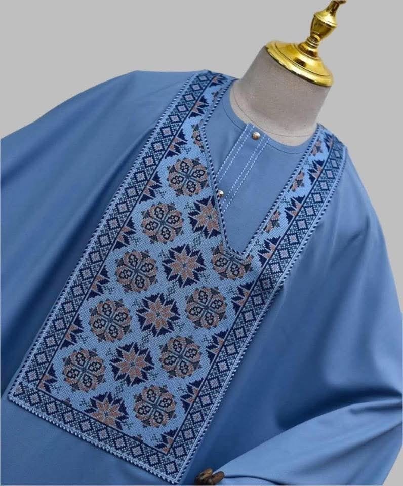 Close-up of blue traditional fabric with intricate embroidered neckline